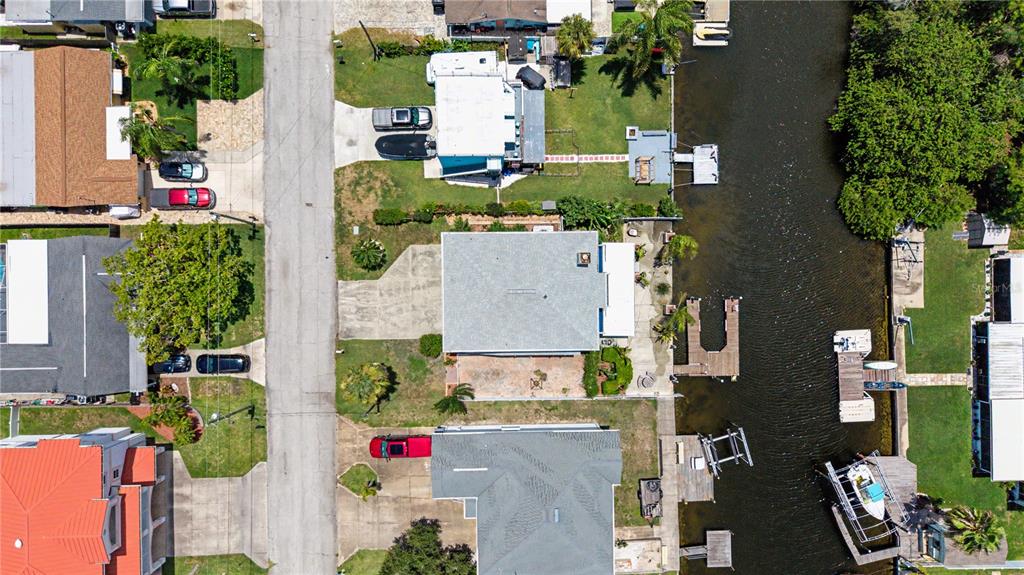An aerial view shows several waterfront houses with docks and boats along a canal — 13337 SUSAN DRIVE, HUDSON, FL