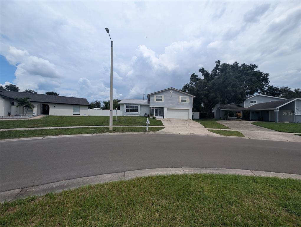 A two-story house with light blue siding, a white brick facade, and a red SUV — 6817 MITCHELL CIRCLE, TAMPA, FL