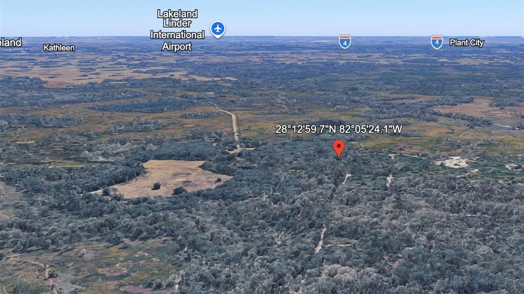 This is an aerial map view showing a red location pin over a wooded area — UNKNOWN, KATHLEEN, FL