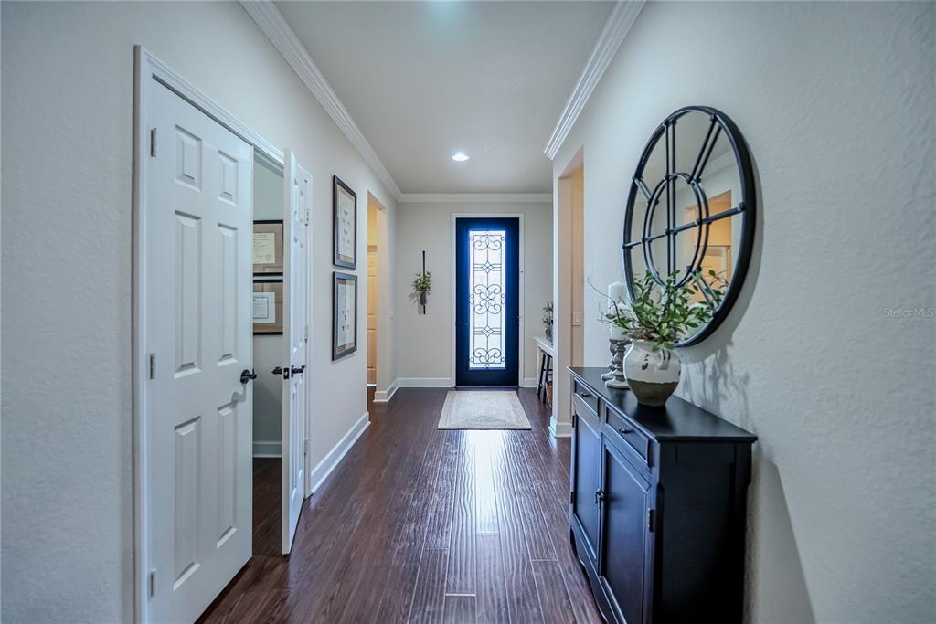 A hallway features dark wood flooring, a black front door, and a black console table — 9163 SW 70TH LOOP, OCALA, FL