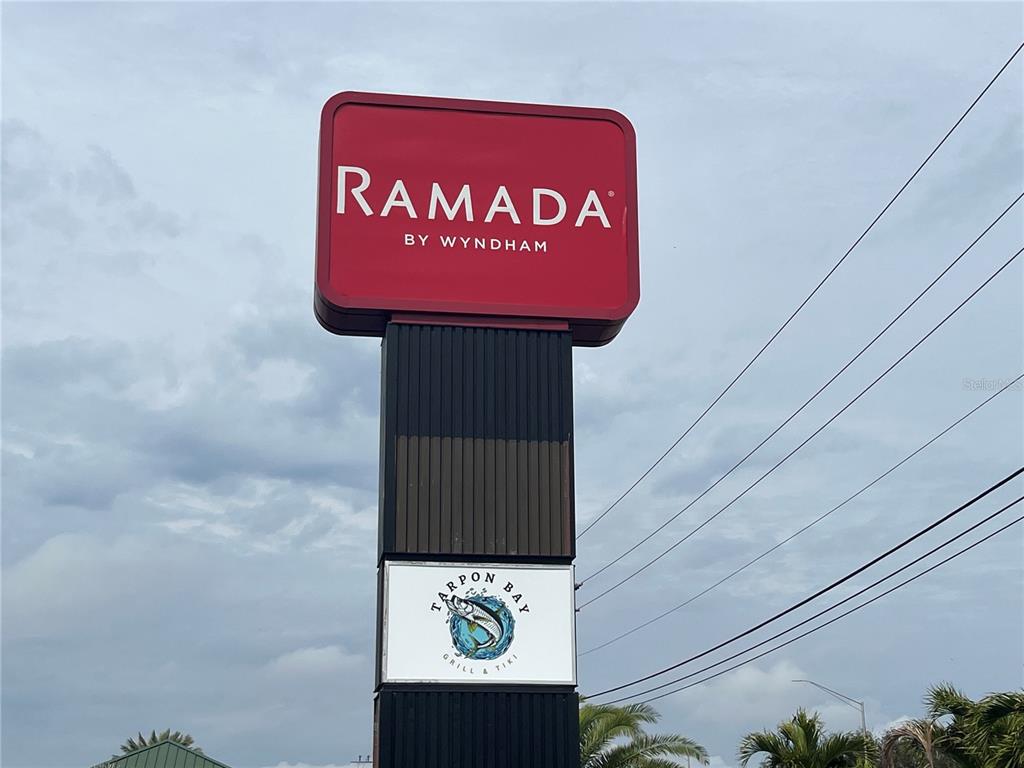 A tall sign for a Ramada by Wyndham hotel stands against a cloudy sky — 7150 N TAMIAMI TRAIL UNIT S510, SARASOTA, FL