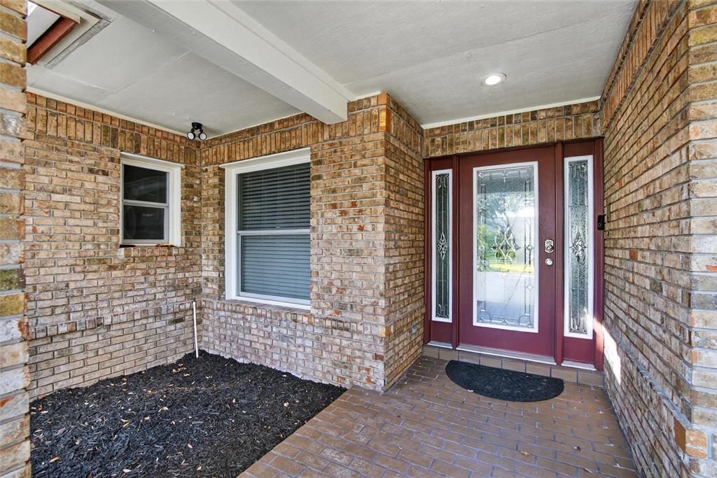A brick-walled front porch features a red front door with glass sidelights and windows — 133 BARRINGTON DRIVE, BRANDON, FL