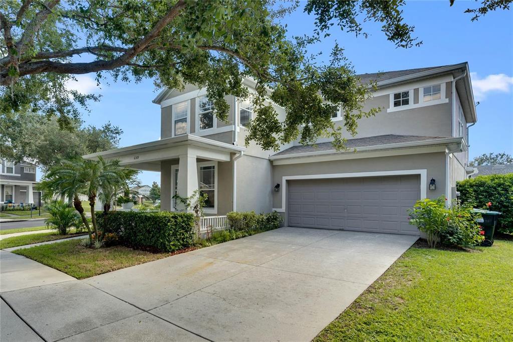 A two-story house with a gray exterior, a two-car garage, and a front porch — 6309 EARTHGOLD DRIVE, WINDERMERE, FL