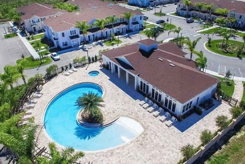 An aerial view of a community clubhouse with a curved swimming pool and surrounding parking — 8953 SHINE DRIVE, KISSIMMEE, FL