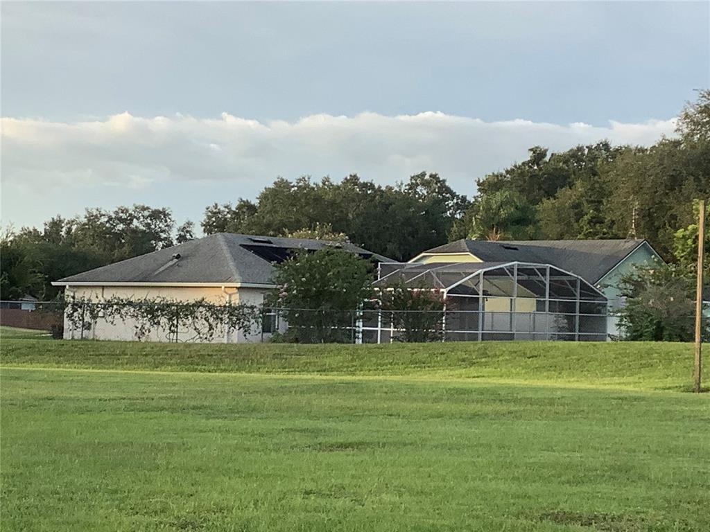 A backyard features a swimming pool enclosed by a screen cage next to a house — 665 STEVELYNN CIRCLE, WINTER GARDEN, FL