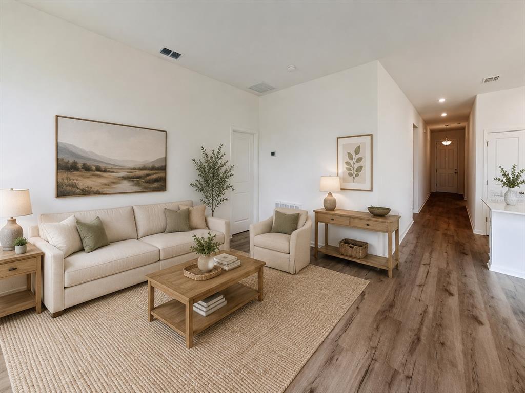 A living room features a beige sofa, armchair, wooden coffee table, and light wood flooring — 6213 SANDERS GROVE CIRCLE, LEESBURG, FL