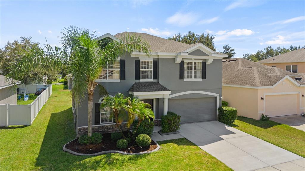 A two-story gray house with a two-car garage and a palm tree in the front — 10313 CYPRESS TRAIL DRIVE, ORLANDO, FL