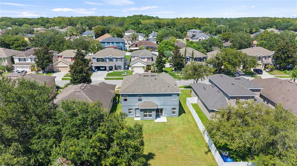 An aerial view shows a two-story house with a large backyard and surrounding neighborhood homes — 10313 CYPRESS TRAIL DRIVE, ORLANDO, FL