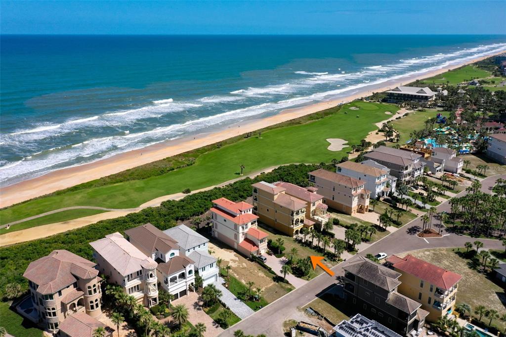 An aerial view shows a row of multi-story houses situated along a beach and golf course — 356 OCEAN CREST DRIVE, PALM COAST, FL