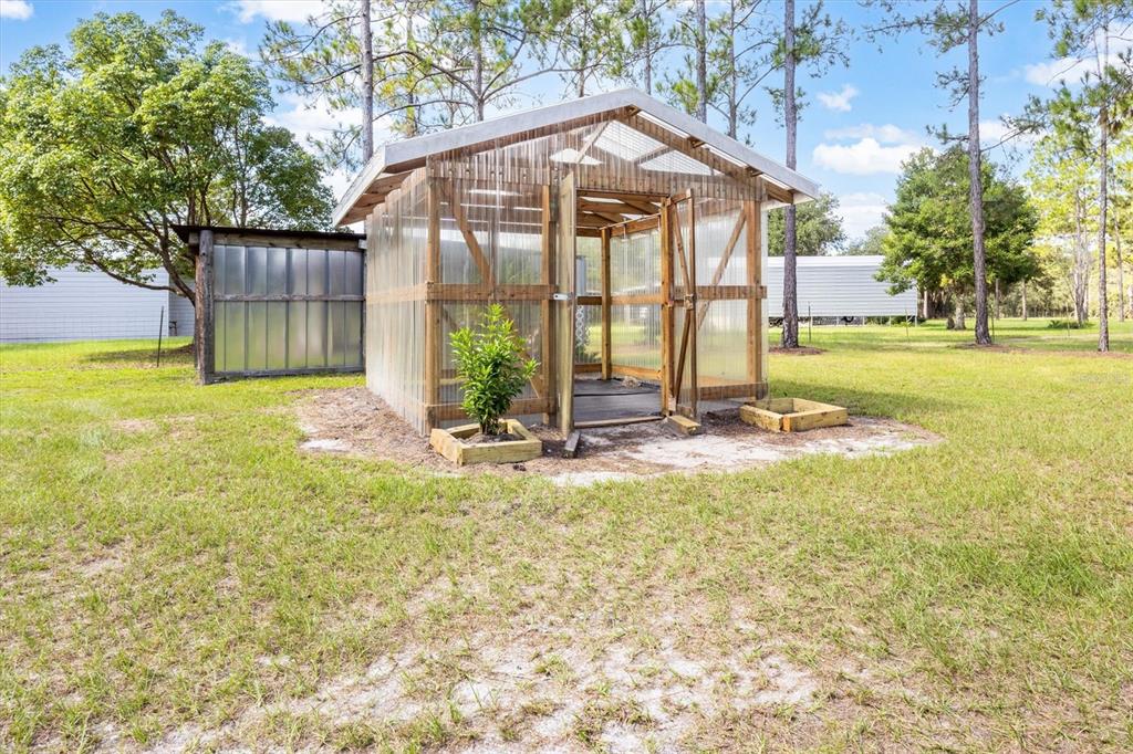 An aerial view shows a light-colored house with a metal roof inside a fenced yard — 17925 SE 49TH PLACE, HAWTHORNE, FL