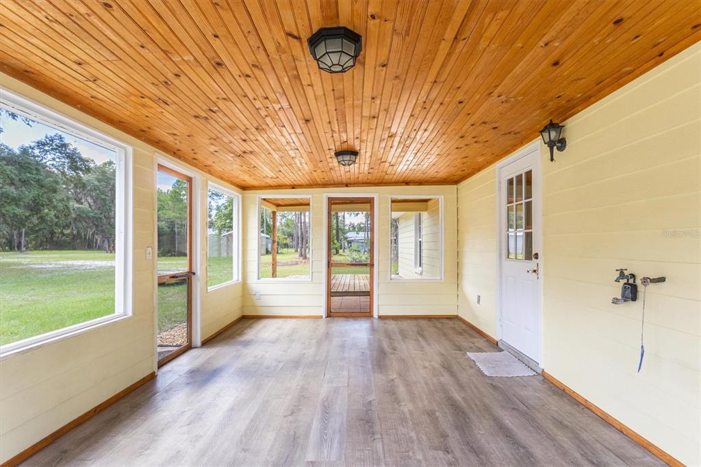A yellow single-story house sits on a large grassy lot surrounded by mature trees — 17925 SE 49TH PLACE, HAWTHORNE, FL