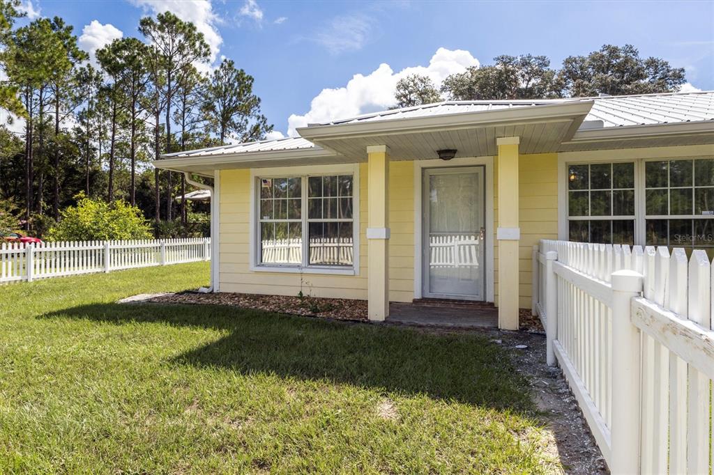 A large wooden pole barn structure stands in a grassy yard with a dirt driveway — 17925 SE 49TH PLACE, HAWTHORNE, FL