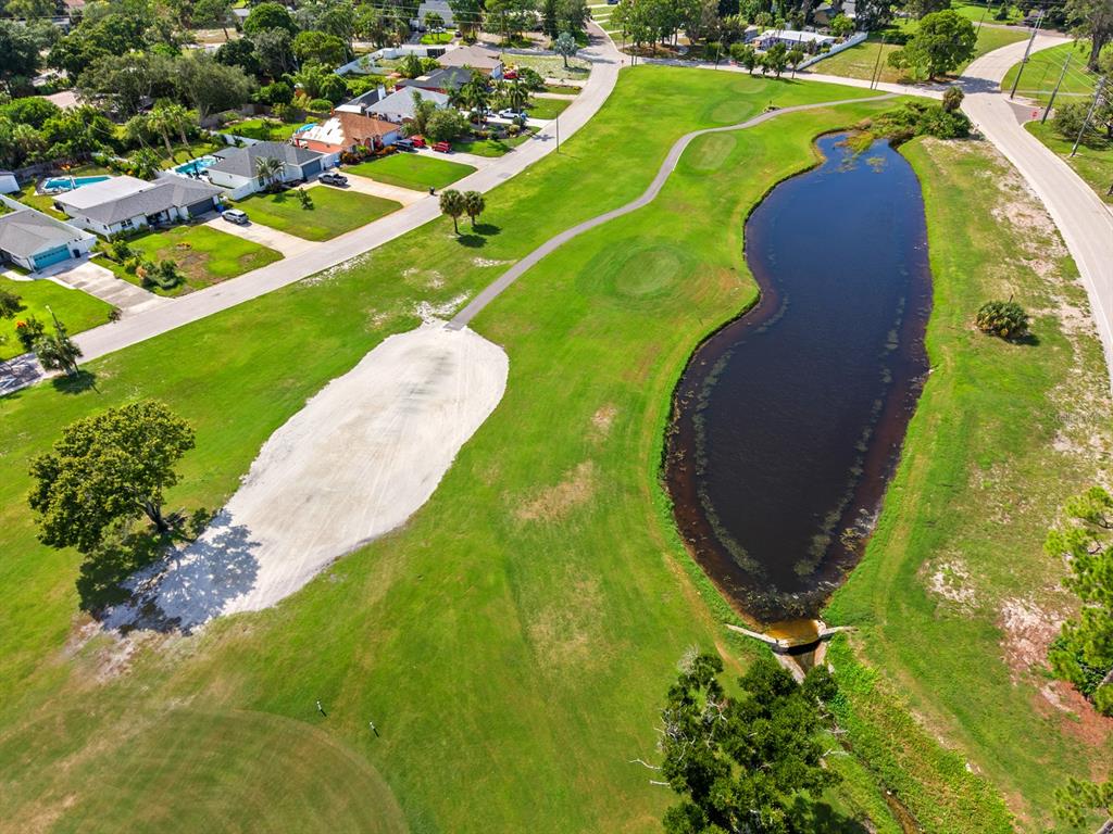 An aerial view of a golf course fairway with a sand bunker and a large pond — 2159 BARCELONA WAY S, ST PETERSBURG, FL