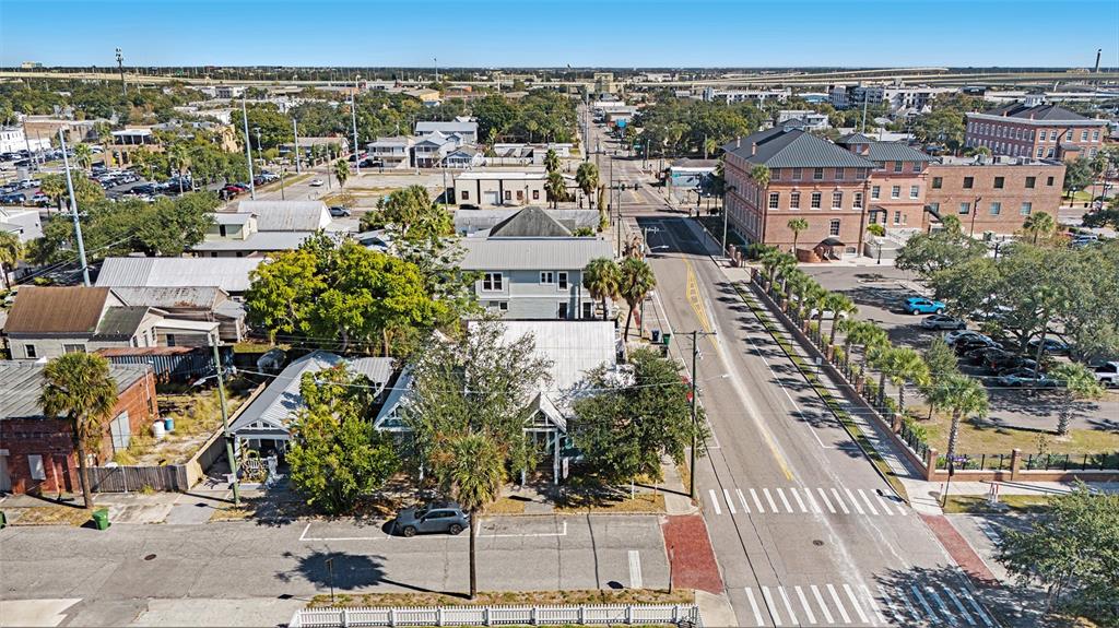An aerial view shows a street scene with historic buildings, parking lots, and palm trees — 2002 E 4TH AVENUE, TAMPA, FL