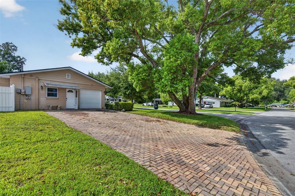 A tan house with a brick driveway and a large tree in the front yard — 2641 CARVELL COURT, WINTER PARK, FL