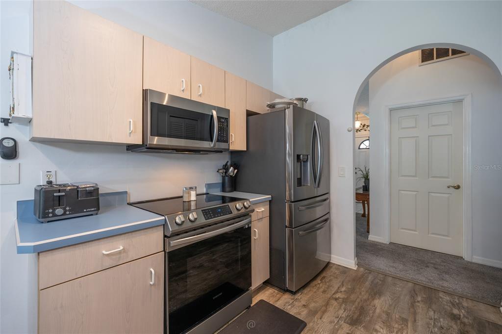 A kitchen features light wood cabinets, stainless steel appliances, and a blue countertop — 6 BOXWOOD LANE, PALM COAST, FL