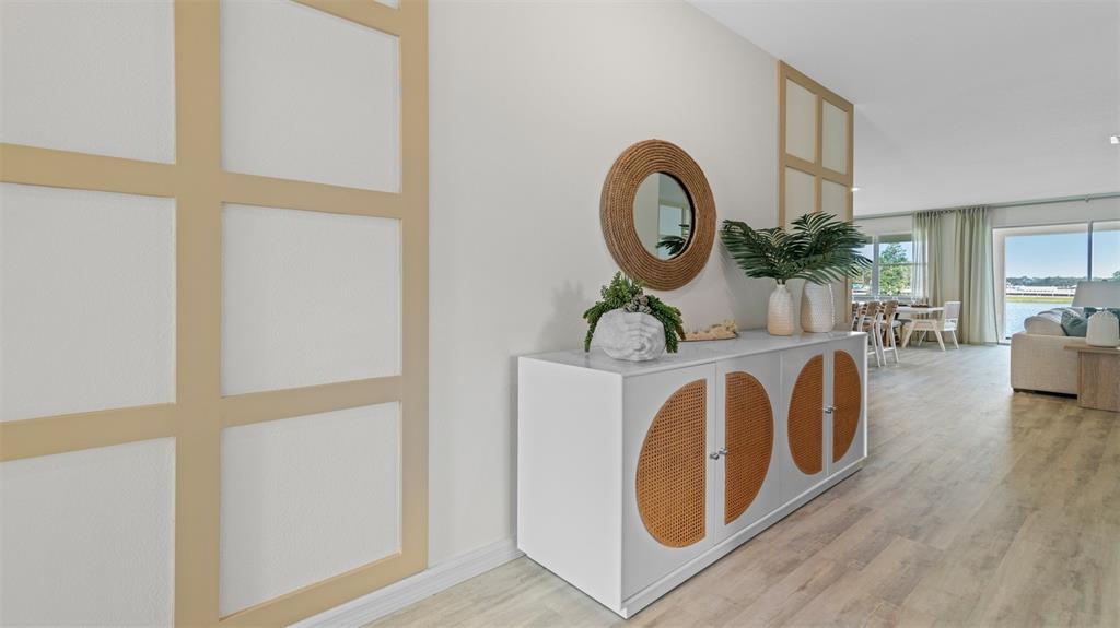A white sideboard with cane doors sits against a wall with light-colored wood paneling — 3033 KINGSMAN TRAIL, ORMOND BEACH, FL