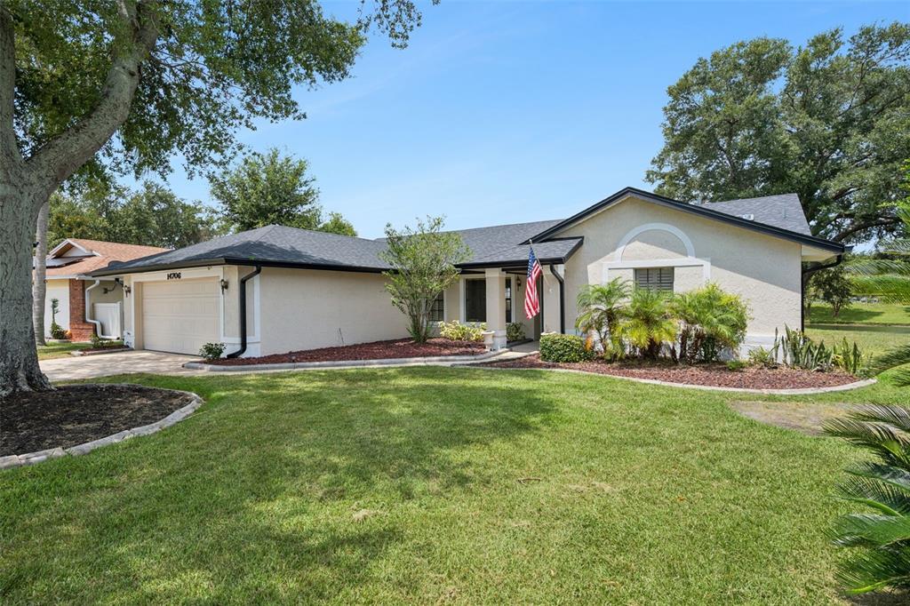 A single-story house features a teal front door, a walkway, and an American flag — 14706 EAGLE VIEW COURT, ORLANDO, FL