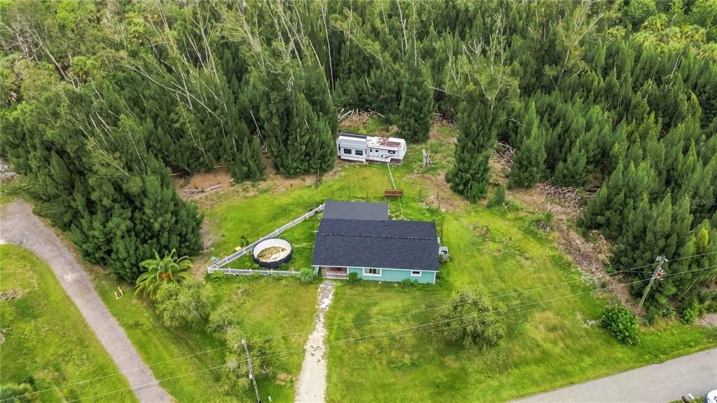 An aerial view shows a house with a black roof, a small pool, and a trailer — 4275 SOUTHLAND AVENUE, PORT CHARLOTTE, FL