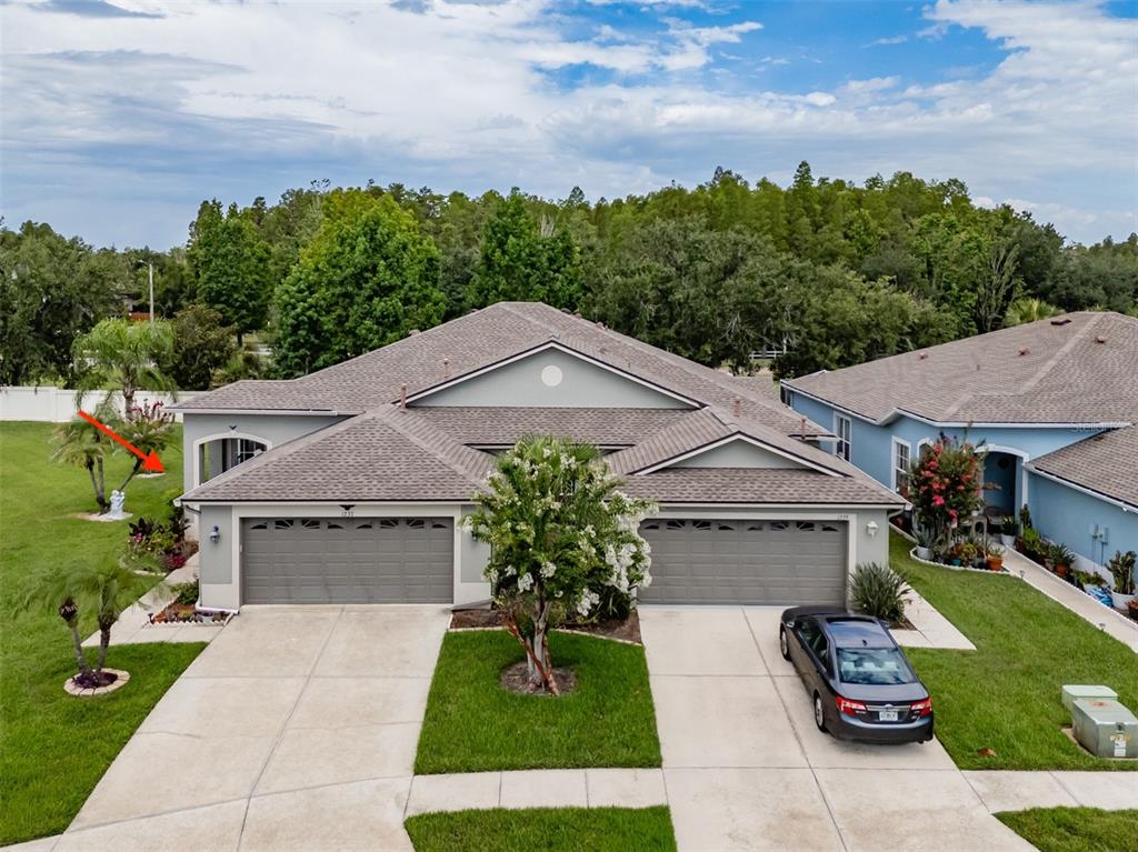 An aerial view of a duplex house with two garages, a driveway, and landscaped lawn — 1237 AMBRIDGE DRIVE, WESLEY CHAPEL, FL
