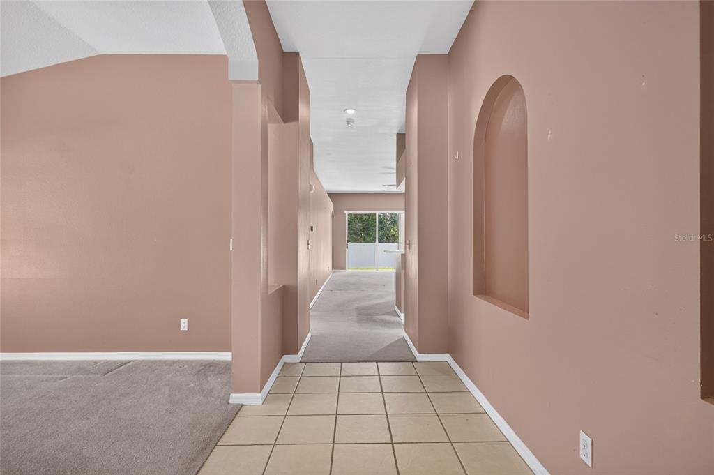 A tiled entryway leads into a carpeted living area with arched wall niches — 2701 BROOKVILLE DRIVE, VALRICO, FL