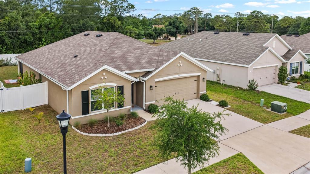 An aerial view of a single-story tan house with a two-car garage and driveway — 1911 BLUE STREAM STREET, RUSKIN, FL