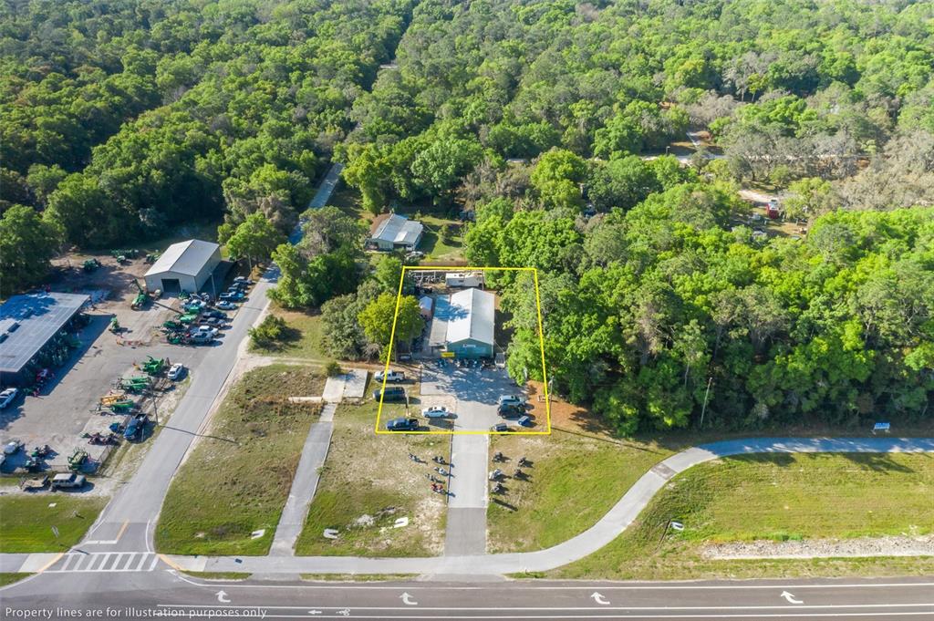 An aerial view shows a commercial building outlined in yellow, surrounded by trees and pavement — 17022 CORTEZ BOULEVARD, BROOKSVILLE, FL