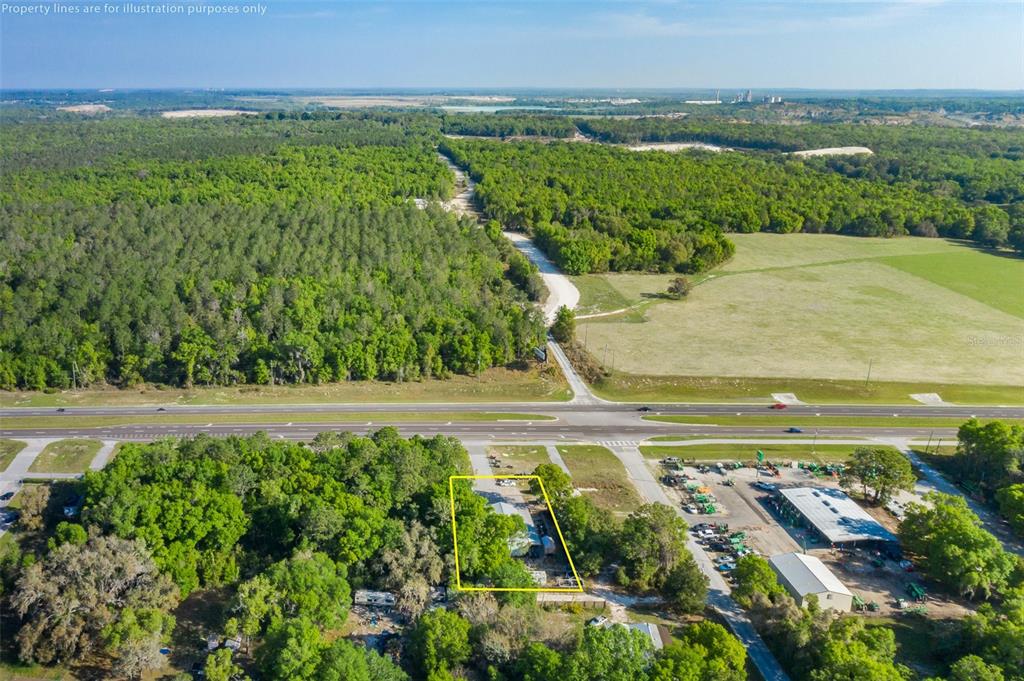 An aerial view shows a rectangular property lot outlined in yellow near a highway — 17022 CORTEZ BOULEVARD, BROOKSVILLE, FL