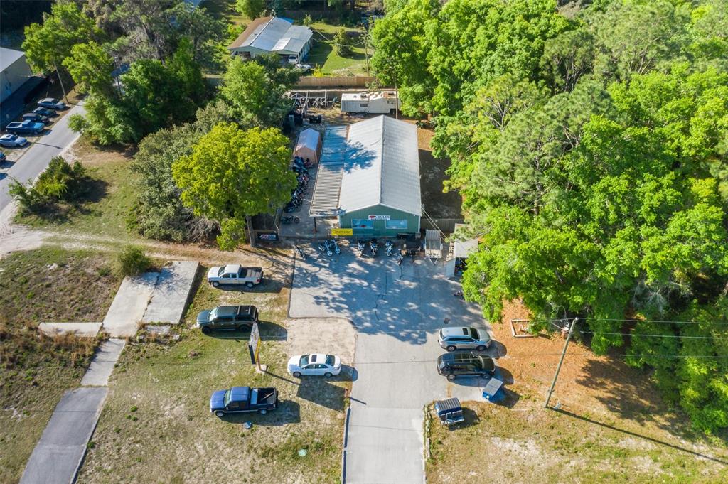 An aerial view shows a commercial building with a parking lot and surrounding trees — 17022 CORTEZ BOULEVARD, BROOKSVILLE, FL