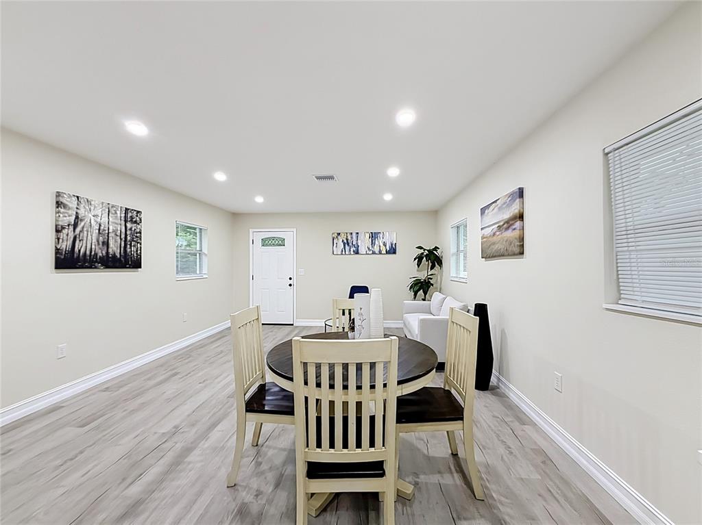 A dining area with a round table and chairs sits in a room with light flooring — 38910 MERRELL AVENUE, UMATILLA, FL