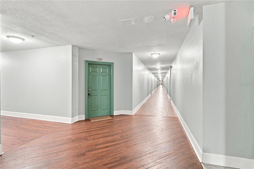 An aerial view shows a large yellow apartment complex with a parking lot and railroad tracks — 860 N ORANGE AVENUE UNIT 239, ORLANDO, FL