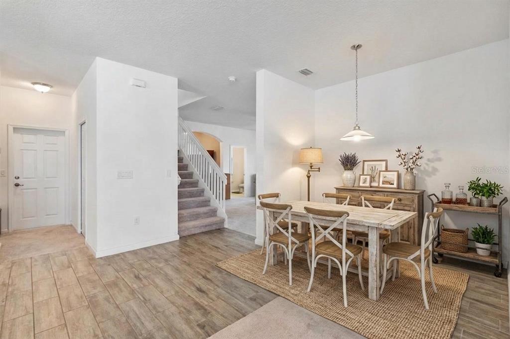 A kitchen with white cabinets, stainless steel appliances, a center island, and wood-look tile flooring — 16021 CHAMPLAIN STREET, CLERMONT, FL