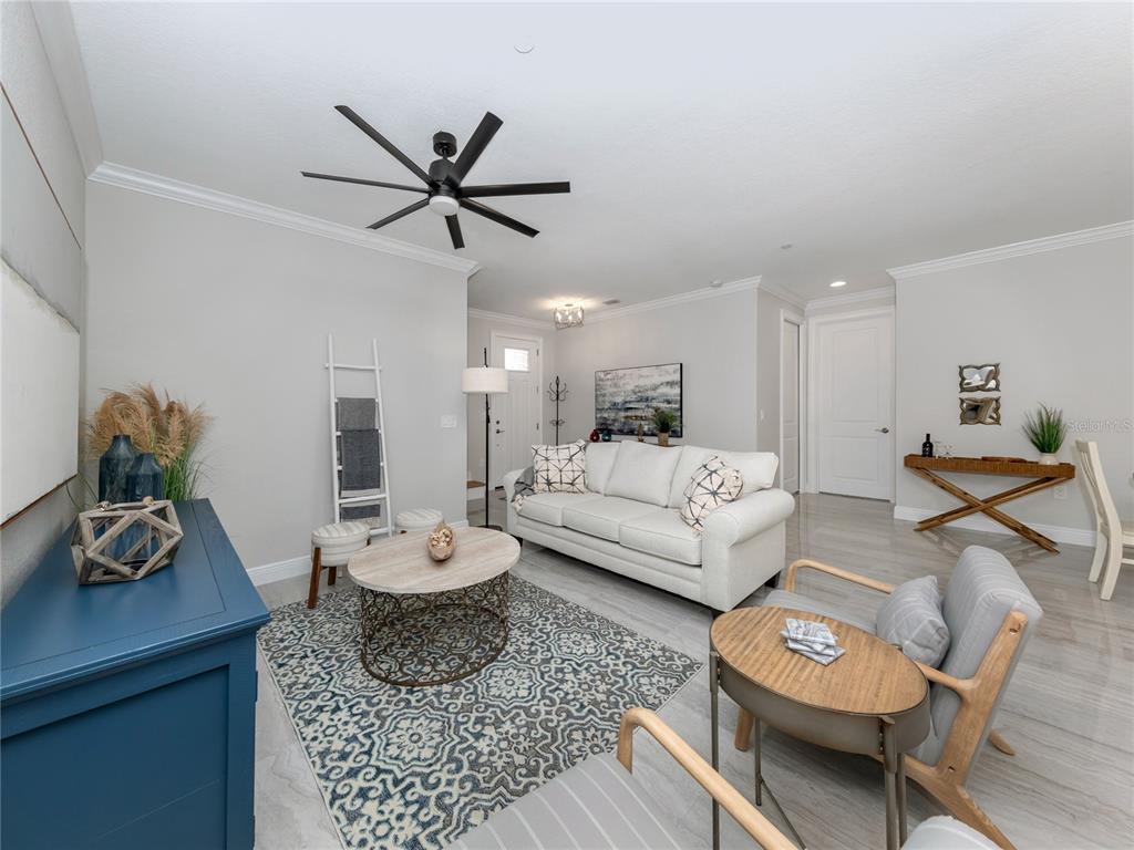A living room features a white sofa, patterned rug, blue cabinet, and light-colored tile flooring — 934 E VENICE AVENUE, VENICE, FL