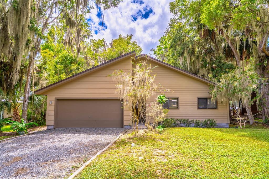An aerial view shows waterfront houses with green lawns and trees along a wide river — 121 N LAKE GEORGE DRIVE, GEORGETOWN, FL