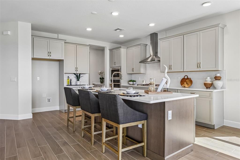 An unfinished kitchen area features a central island, tiled floors, and recessed ceiling lighting — 3209 WOLF LAKE AVENUE, APOPKA, FL