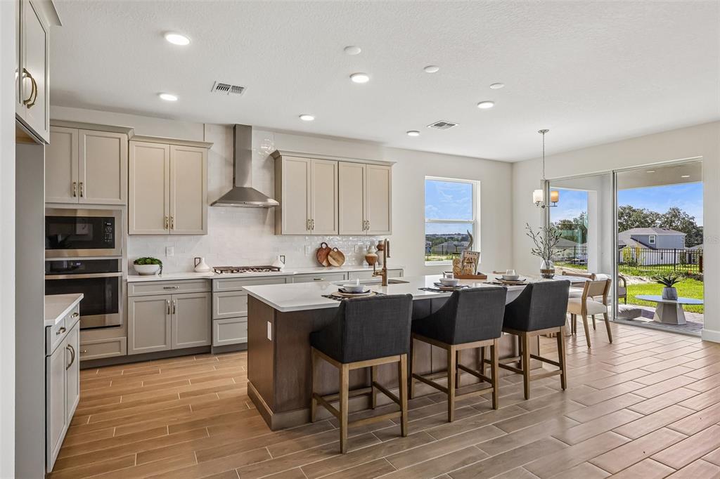 An unfinished kitchen area features a central island, light-colored walls, and wood-look tile flooring — 3209 WOLF LAKE AVENUE, APOPKA, FL