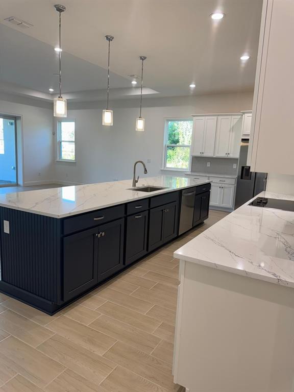 A kitchen features a dark blue island with a white marble countertop and pendant lighting — 1138 CLIFFHAVEN COURT, ORMOND BEACH, FL