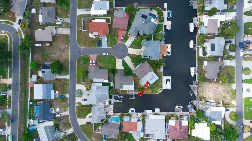 This aerial view shows a residential neighborhood with houses situated along a canal — 318 CIRCLE DRIVE, PALM HARBOR, FL
