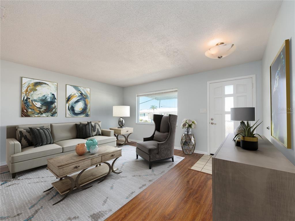 This living room features a light-colored sofa, a wingback chair, and wood-look flooring — 9157 140TH WAY, SEMINOLE, FL