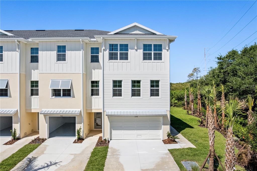 A two-story townhouse with a white exterior, attached garage, and a small front lawn — 7398 MARATHON DRIVE, SEMINOLE, FL