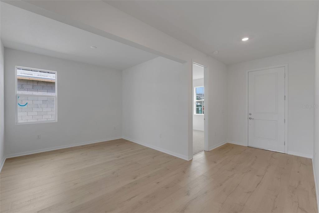 An empty room with light wood-look flooring, white walls, and a white interior door — 16938 SQUIRREL BRANCH LANE, ALVA, FL