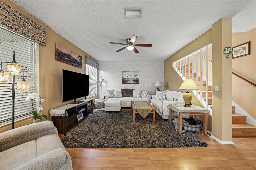 A living room features a television, a sectional sofa, a rug, and a staircase — 5123 CORVETTE DRIVE, TAMPA, FL