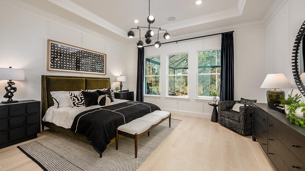 A modern open-concept living room features a white sectional sofa, black coffee table, and kitchen — 997 TASSLEFLOWER TRAIL, ST CLOUD, FL