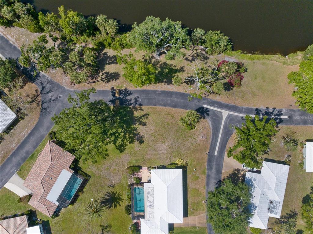 An aerial view shows a residential street, houses with pools, and a nearby lake — 531 VILLA PARK DRIVE UNIT 531, NOKOMIS, FL