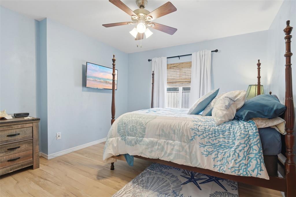 A living room features vaulted ceilings with exposed wooden beams, light flooring, and sliding glass doors — 82 JENNIFER CIRCLE, PONCE INLET, FL