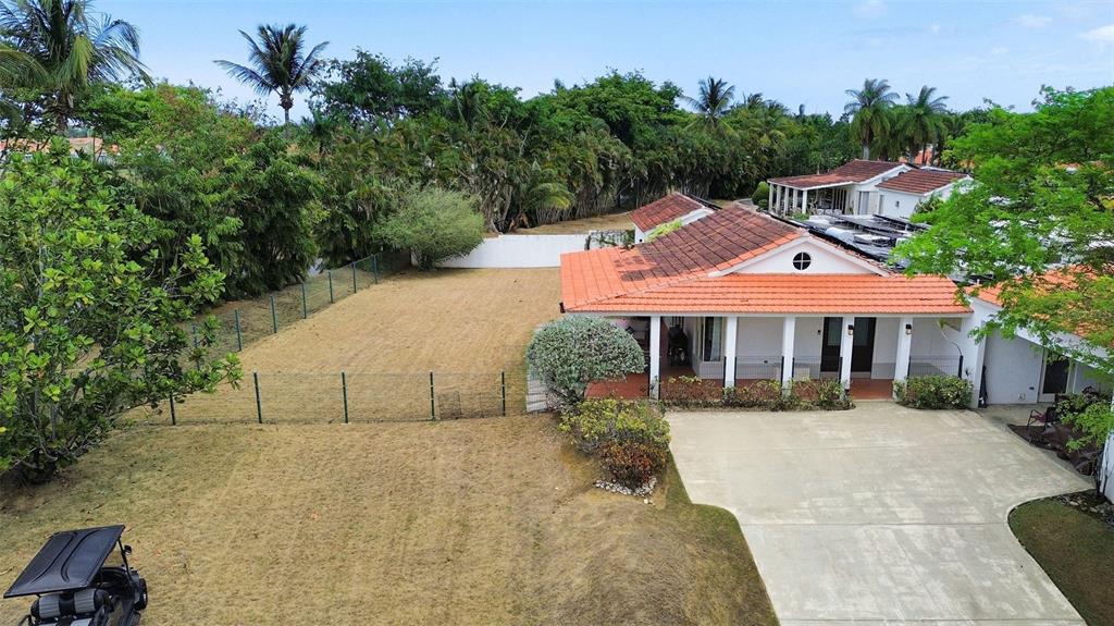 An aerial view shows a house with a red tile roof, concrete driveway, and yard — 134 CAMINO DE LA CANA, DORADO, PR
