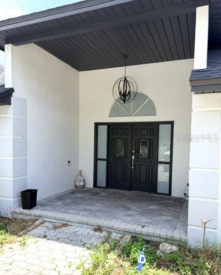 A front entryway features a dark double door, a hanging pendant light, and stone pavers — 1677 SACKETT CIRCLE, ORLANDO, FL