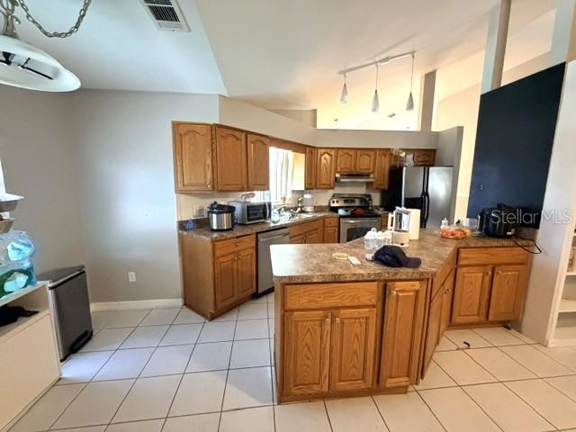 A kitchen features oak cabinets, laminate countertops, and a central island with pendant lighting — 1677 SACKETT CIRCLE, ORLANDO, FL
