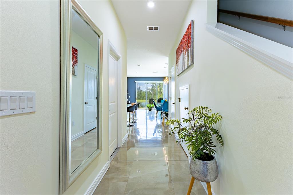 A bright hallway with light tile floors, a large wall mirror, and a potted plant — 2037 CRYSTAL BELL STREET, ORLANDO, FL