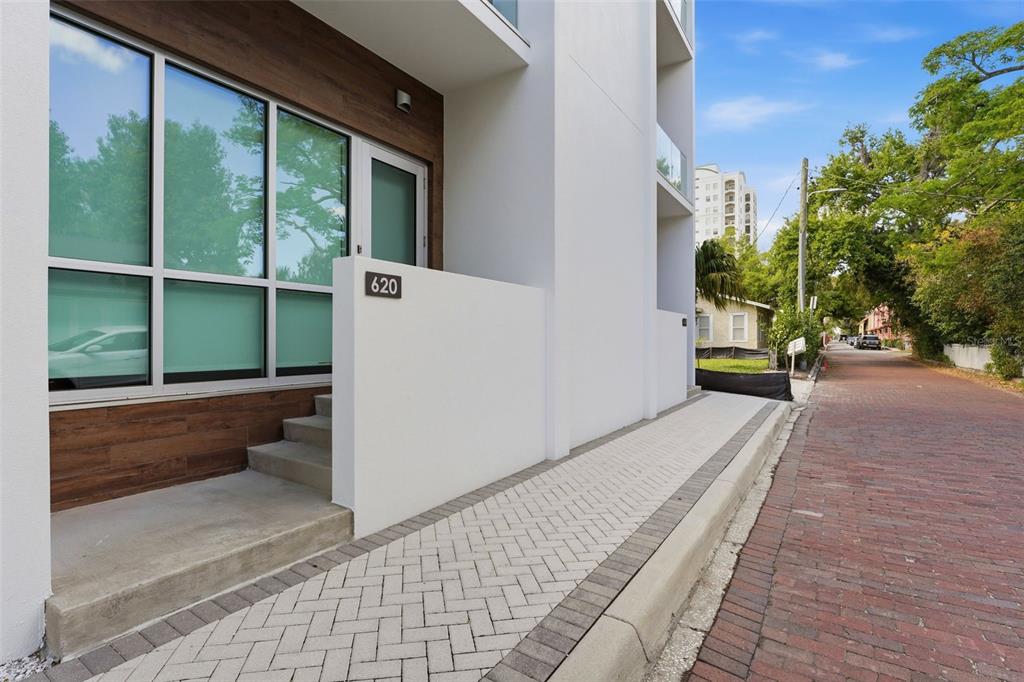 A modern white building with a brick-paved street and a herringbone-patterned sidewalk — 620 RAWLS AVENUE, SARASOTA, FL